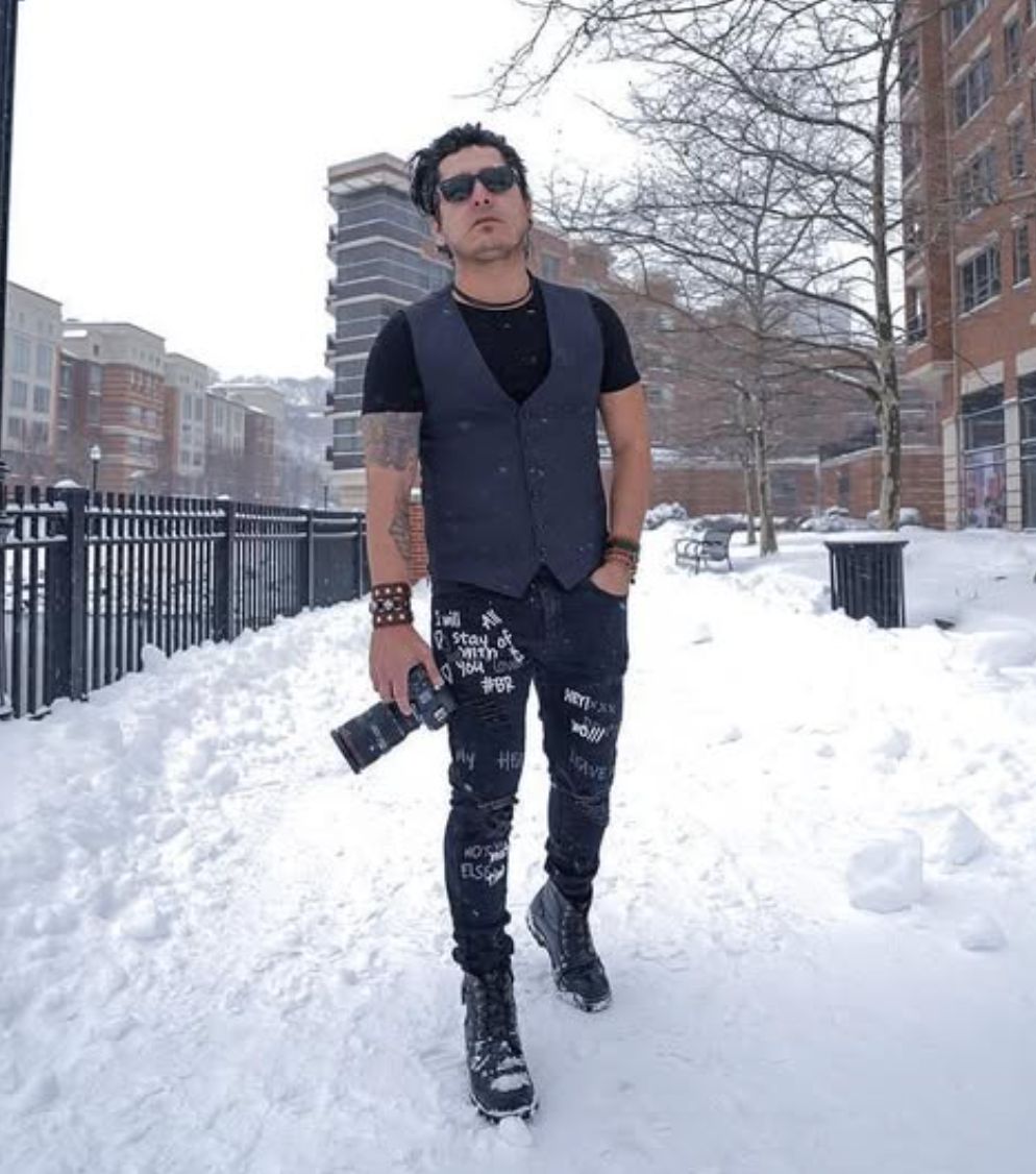 Swami Castro caminando por la nieve con una cámara en la mano
